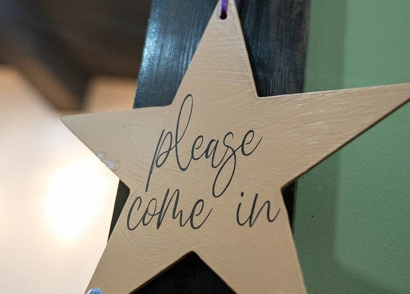 Star-shaped sign with 'please come in' at In the Spalight, Dickson, Tennessee, US.