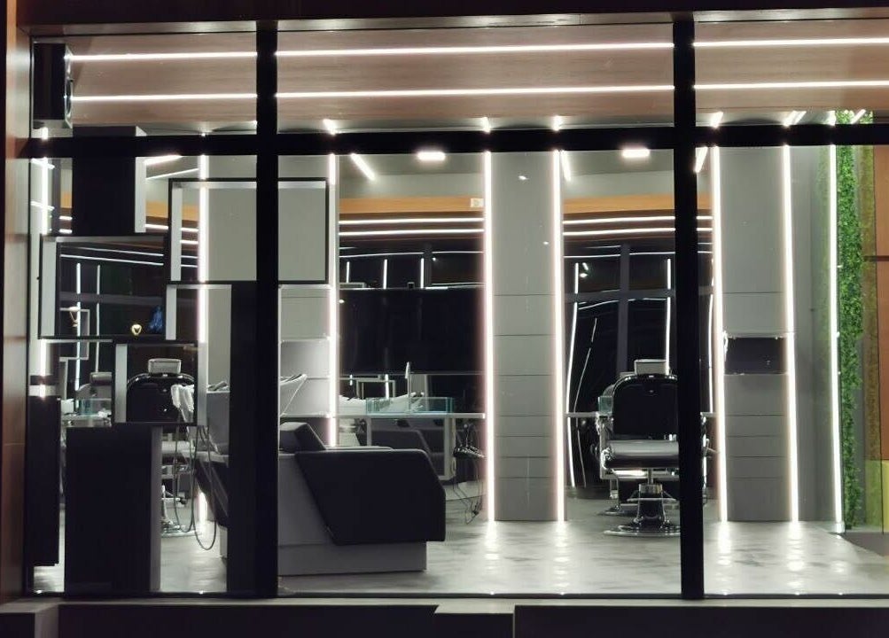 Interno illuminato di Modo Central Barbieria a Porto Sant'Elpidio, Marche, IT, con eleganti postazioni.