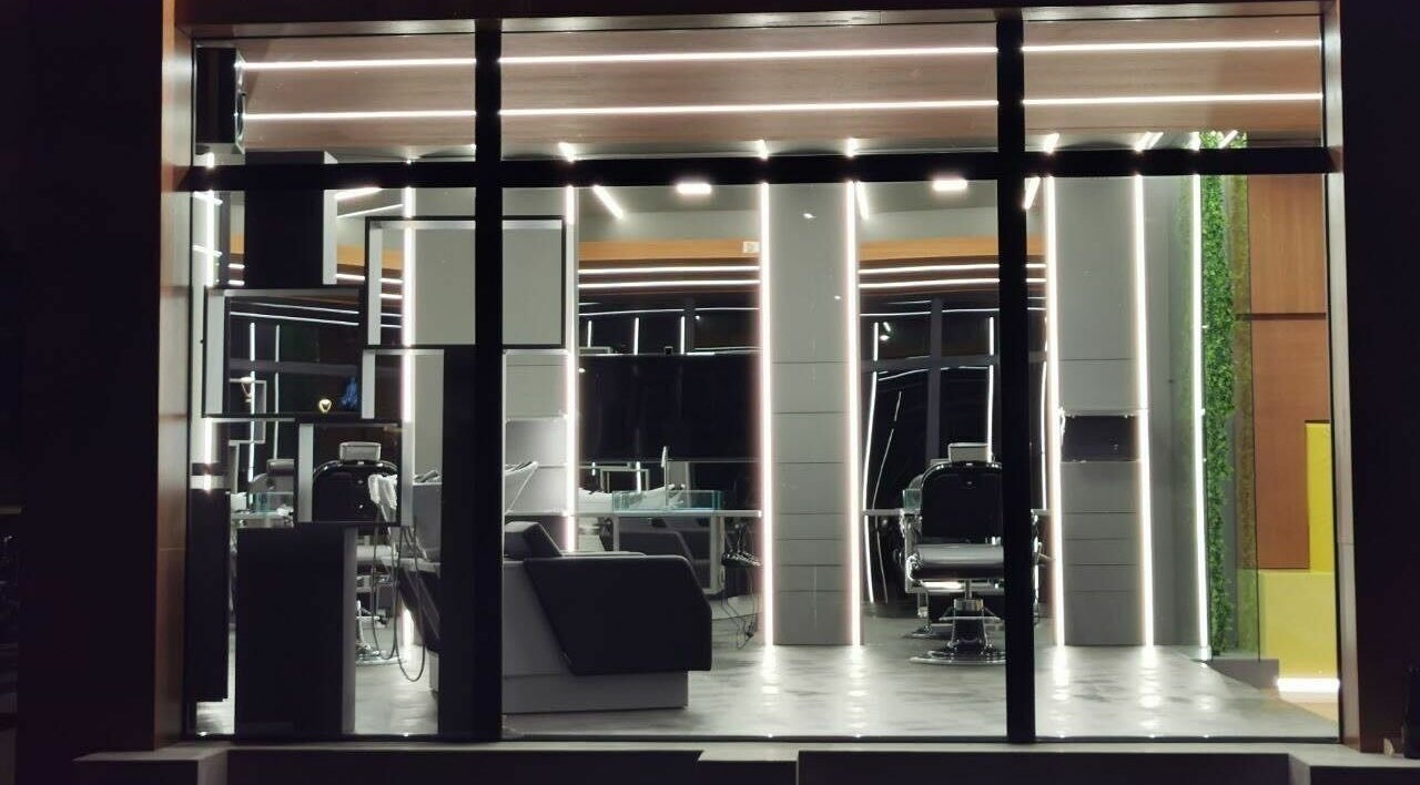 Interno illuminato di Modo Central Barbieria a Porto Sant'Elpidio, Marche, IT, con eleganti postazioni.