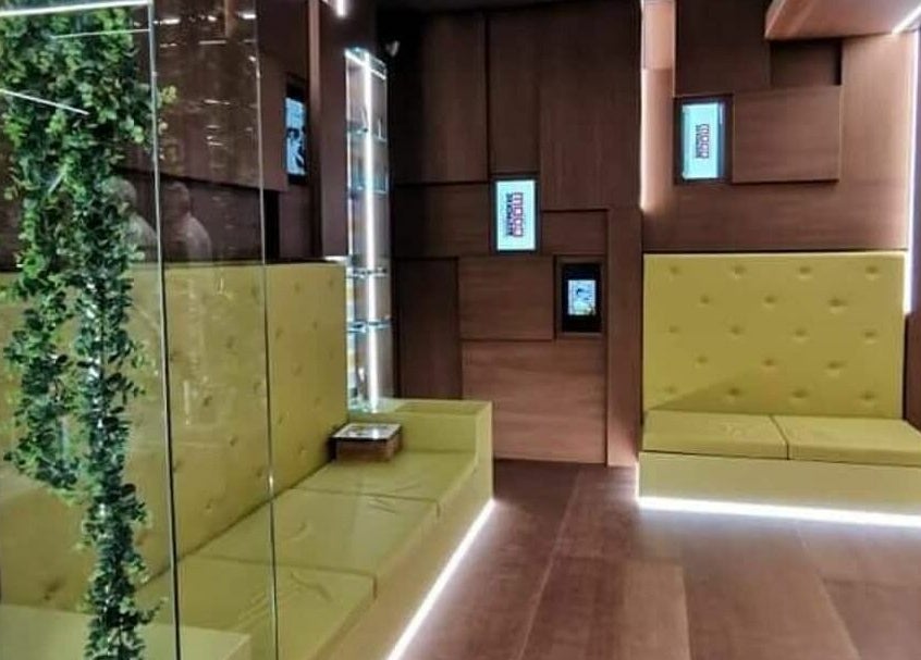 Area salotto moderna con panchine gialle presso Modo Central Barbieria, Porto Sant'Elpidio, Marche, IT.