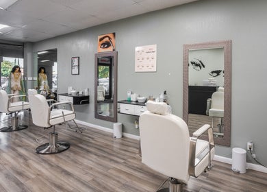 Elegant interior of Eye Bar Beauty Salon in Stockton, California, with stylish chairs and mirrors.