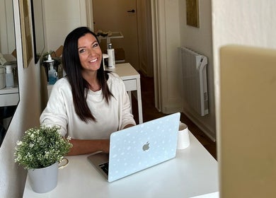Smiling woman at desk in The Beauty Room, Bournemouth, England, GB, creating a welcoming salon atmosphere.