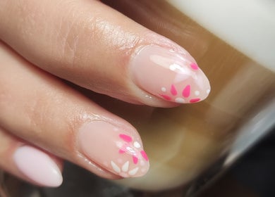 Bloemrijke nagelkunst bij Schoonheidssalon DIVINE Beauty, Helden, Limburg, NL, met een subtiele koffiemotief achtergrond.