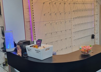 Reception desk at Angel Wellness Centre Salon, Birtley, England, GB, featuring products and ambient lighting.