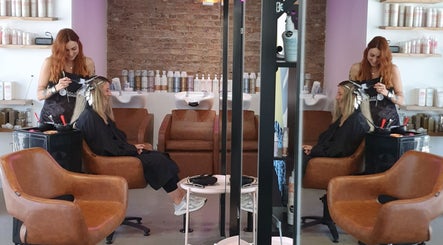 Stylist at Lil Frenchie Hair in Saint Richards, Glebe, NSW, AU creating highlights for a smiling client.