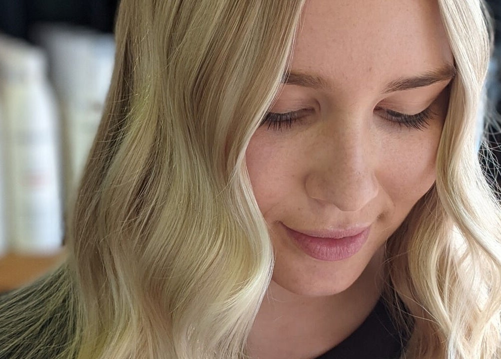 Blonde hair styled elegantly at Colorbox Hair, Coomera, QLD, AU. A serene expression enhances the look.