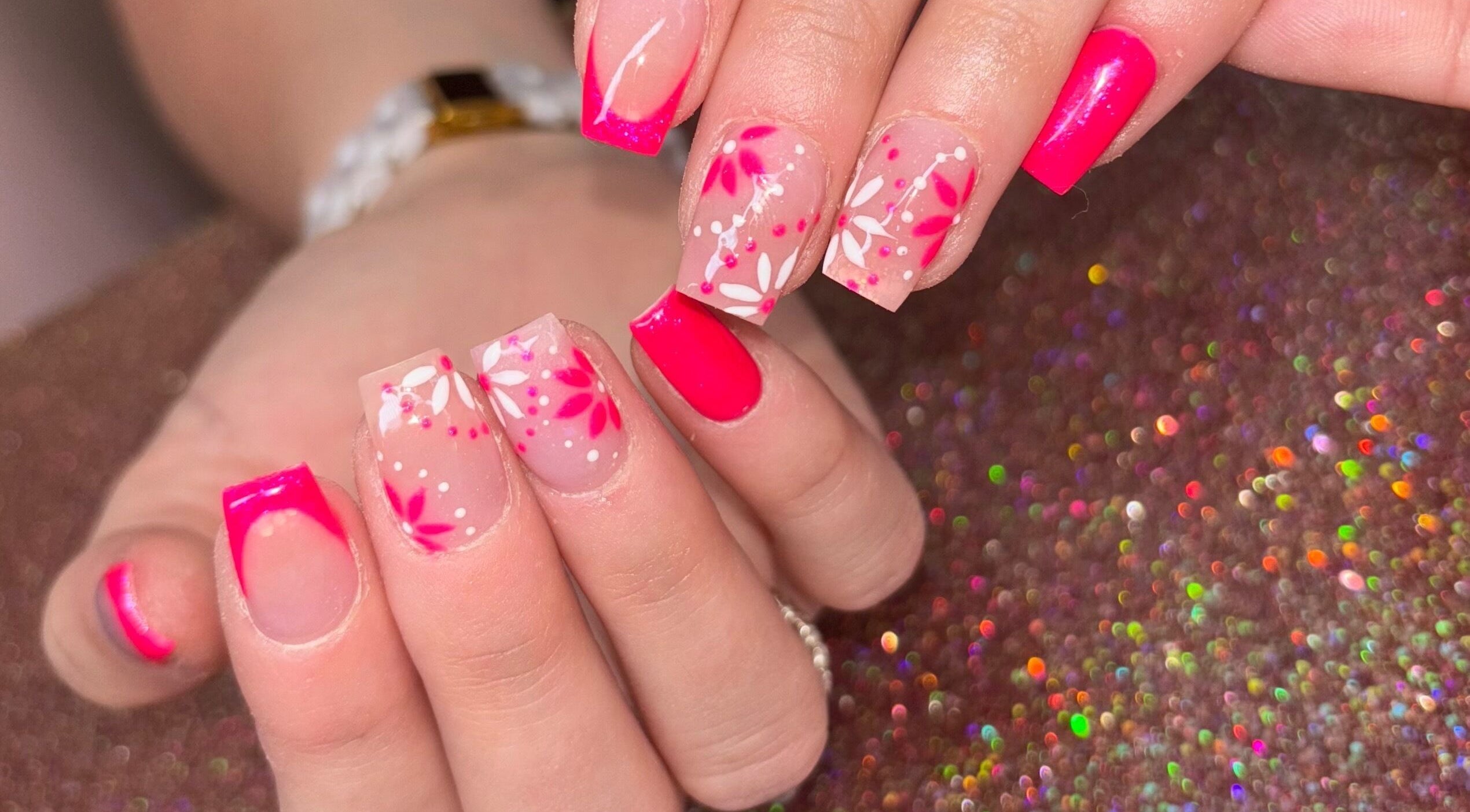 Bright floral nail art at Luxe Beauty MK, Crownhill, England, GB, showcasing intricate pink designs.