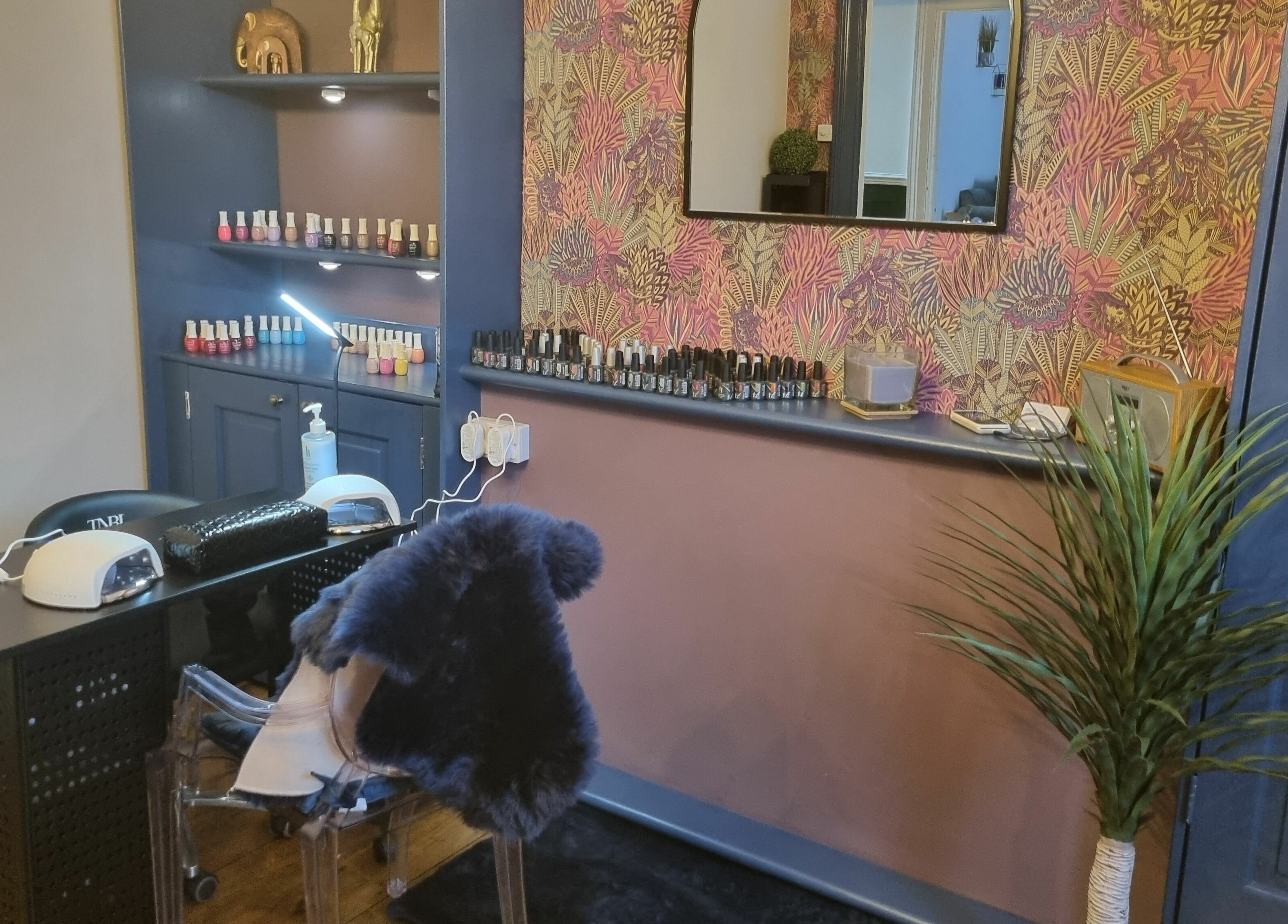 Nail studio at Illusions, Redruth, England, GB featuring a stylish manicure station with colorful polishes.