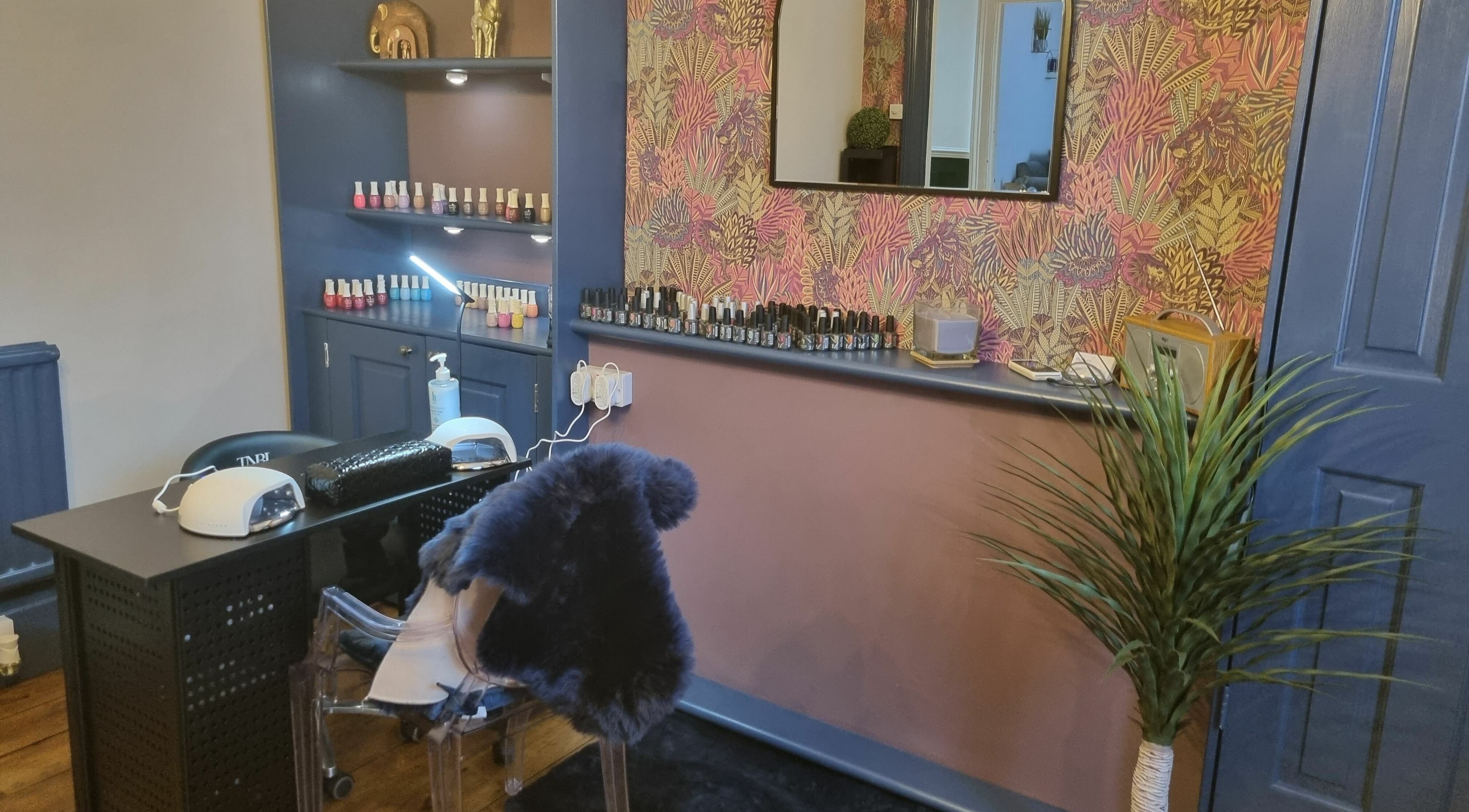 Nail studio at Illusions, Redruth, England, GB featuring a stylish manicure station with colorful polishes.