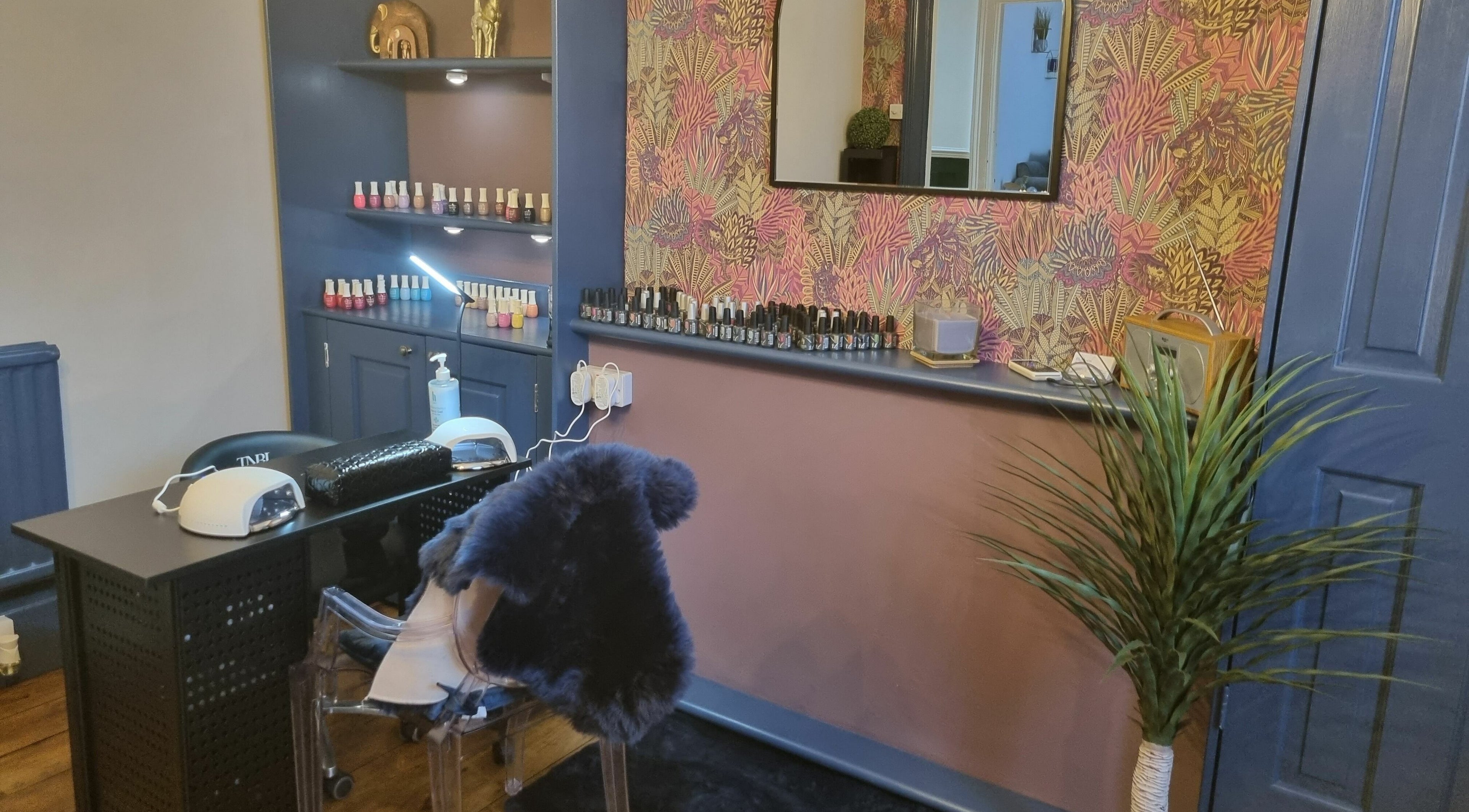 Nail studio at Illusions, Redruth, England, GB featuring a stylish manicure station with colorful polishes.
