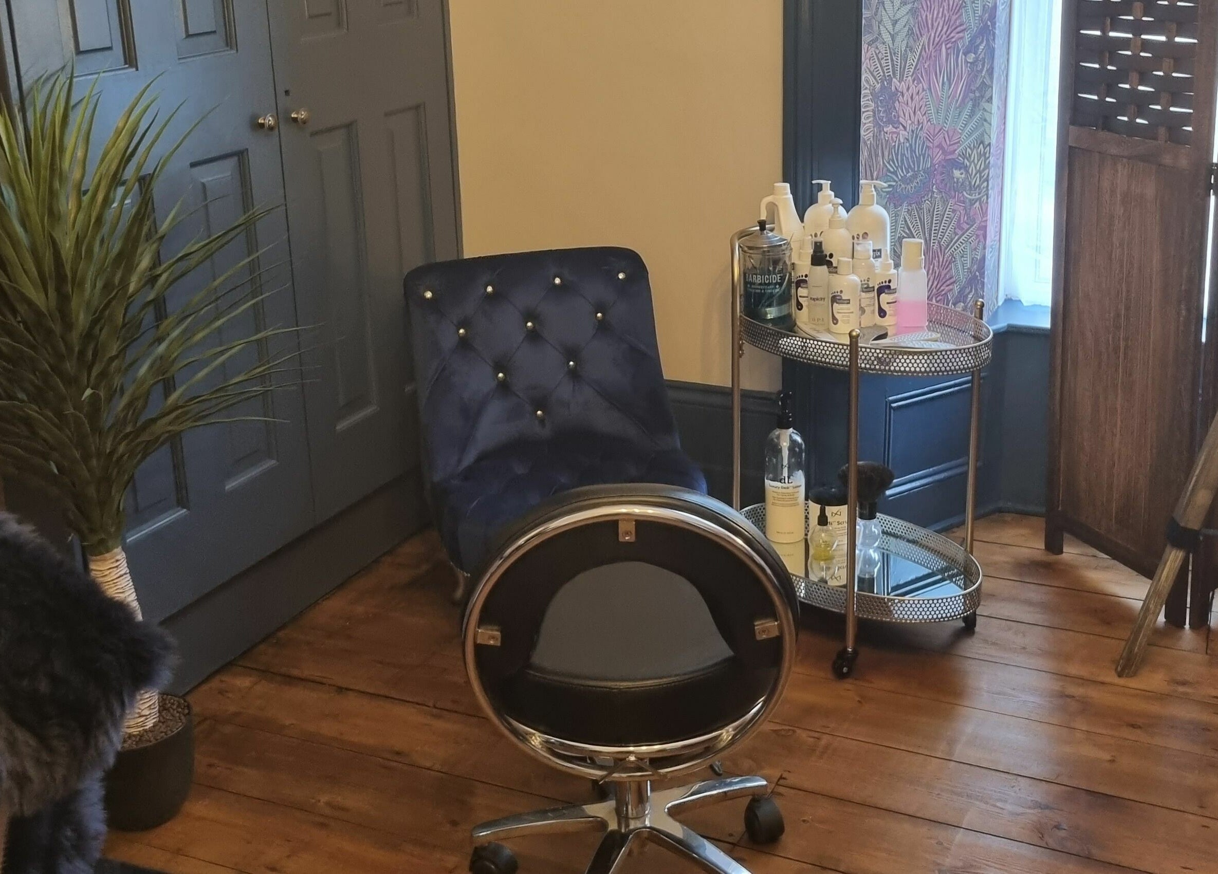 Cozy salon corner at Illusions, Redruth, England, GB with chic chair and beauty products.