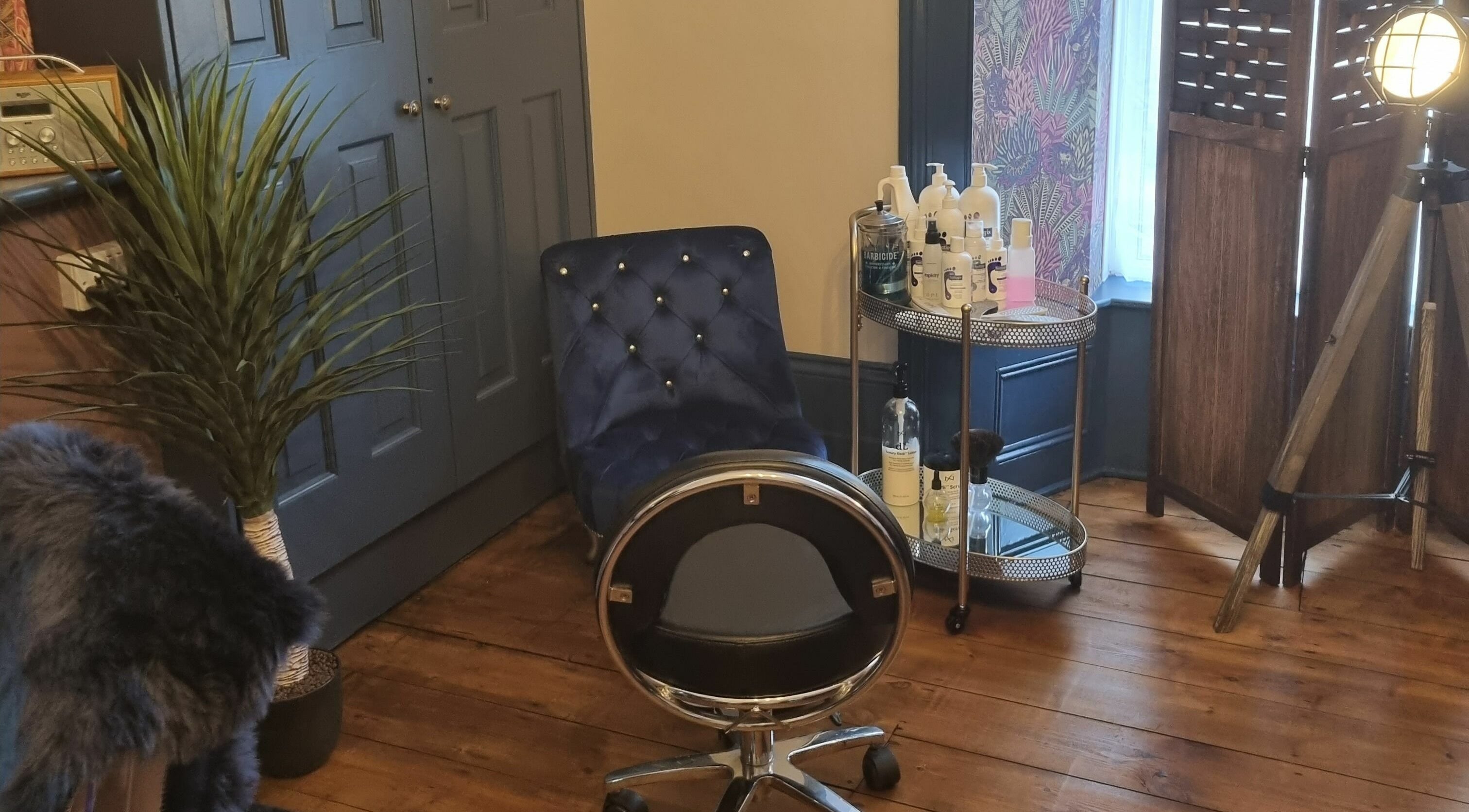 Cozy salon corner at Illusions, Redruth, England, GB with chic chair and beauty products.