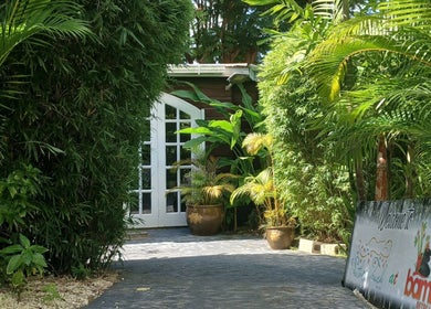 Lush entrance at The Bamboo Retreat in St. George, BB, featuring plants and a welcoming sign.