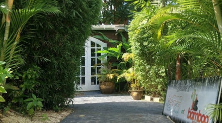 Lush entrance at The Bamboo Retreat in St. George, BB, featuring plants and a welcoming sign.