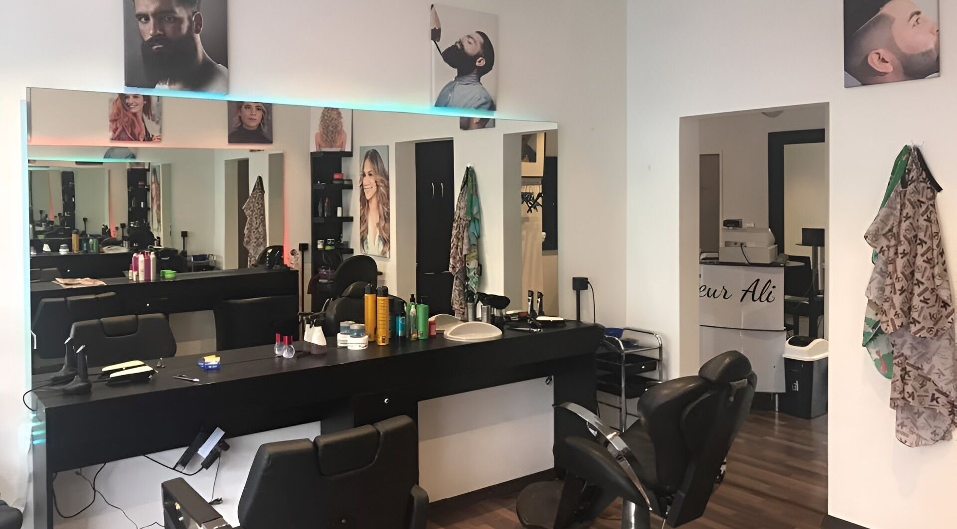 Stilvoller Innenraum von Coiffeur Ali in Zürich, Zürich, CH, mit Friseurstühlen und Spiegeln.