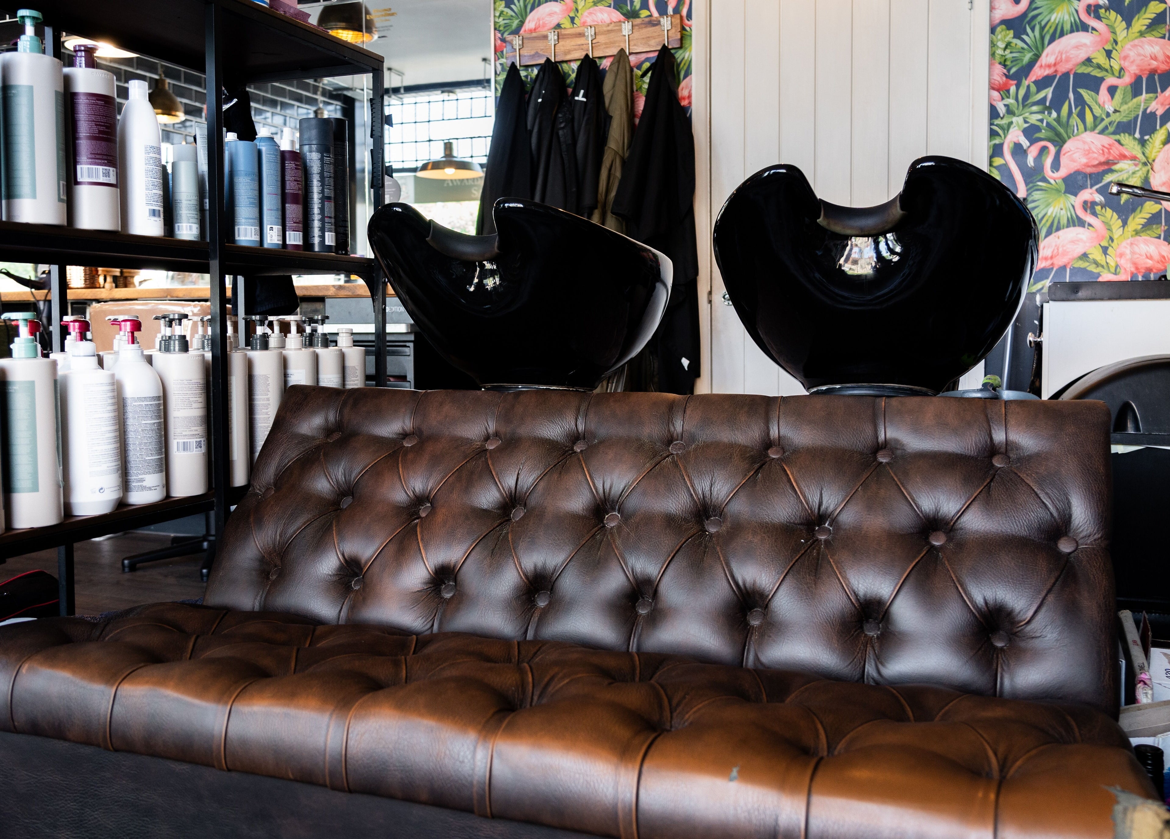 Elegant salon interior with leather sofa at Chandler & Hall, Southbourne, England, GB, enhancing relaxation.