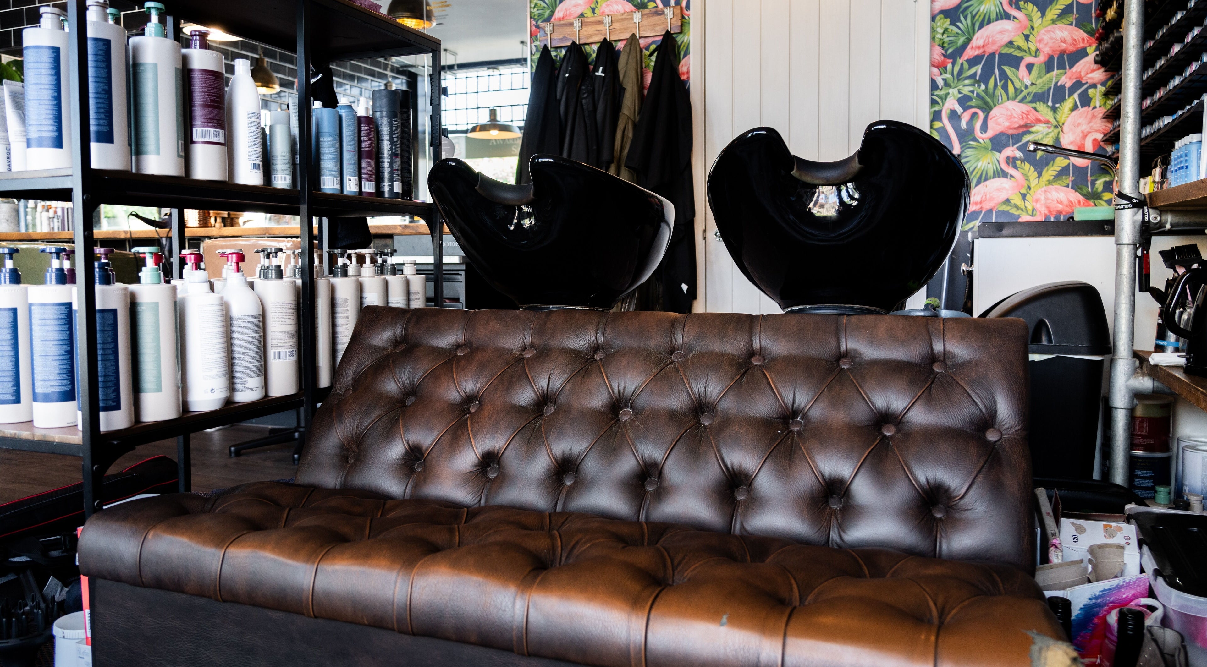 Elegant salon interior with leather sofa at Chandler & Hall, Southbourne, England, GB, enhancing relaxation.
