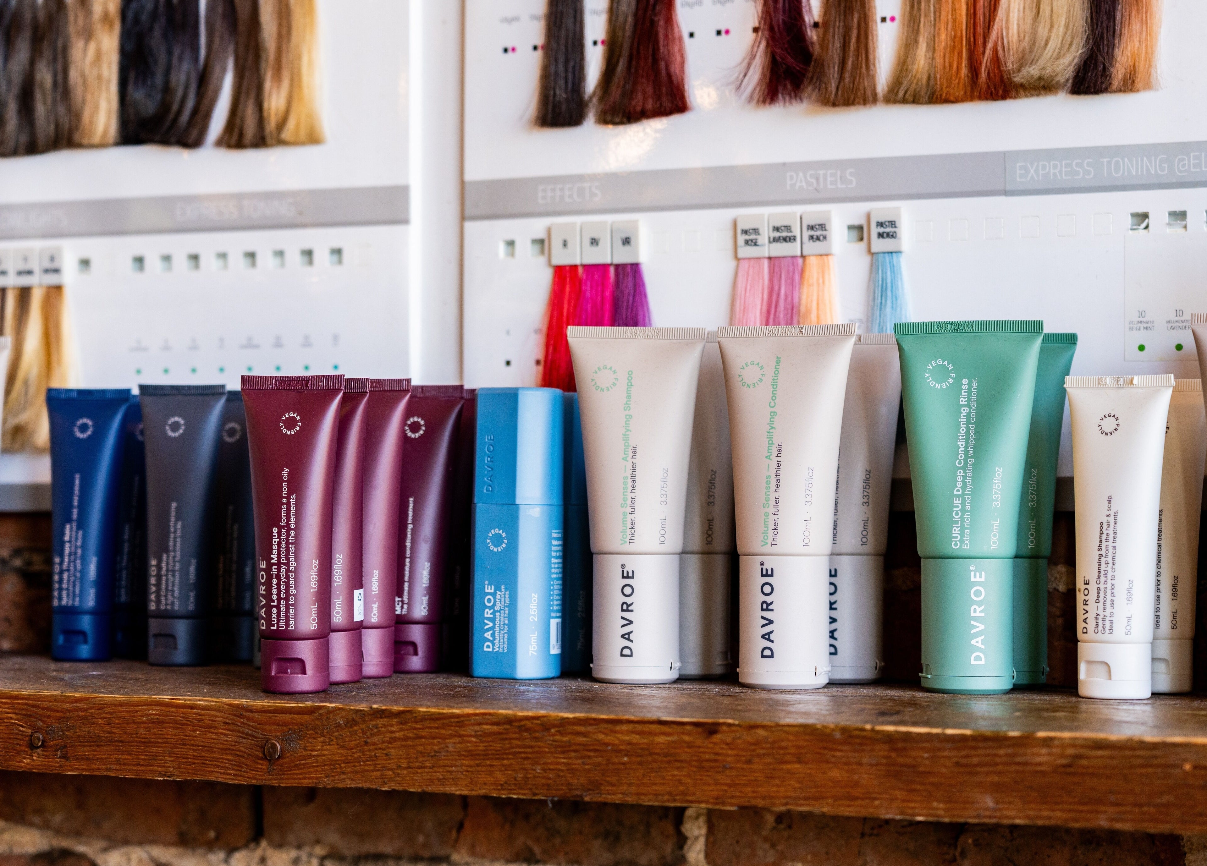 Chandler & Hall in Southbourne, England showcases vibrant hair products lined on a shelf under hair samples.