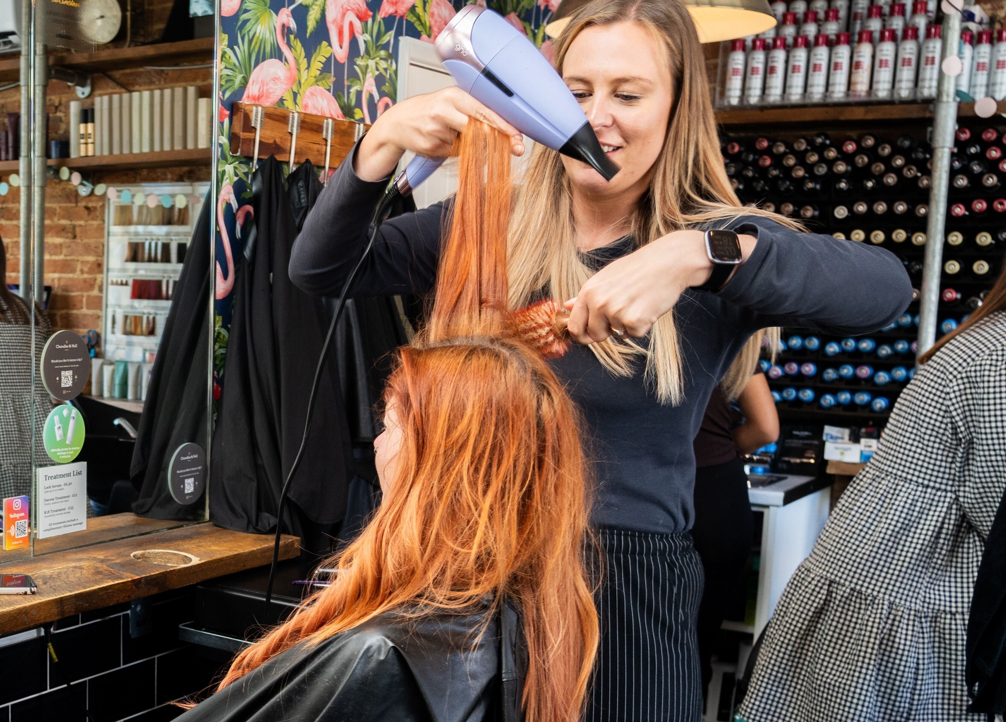 Hair stylist expertly blow-drying client's hair at Chandler & Hall, Southbourne, England, GB salon.