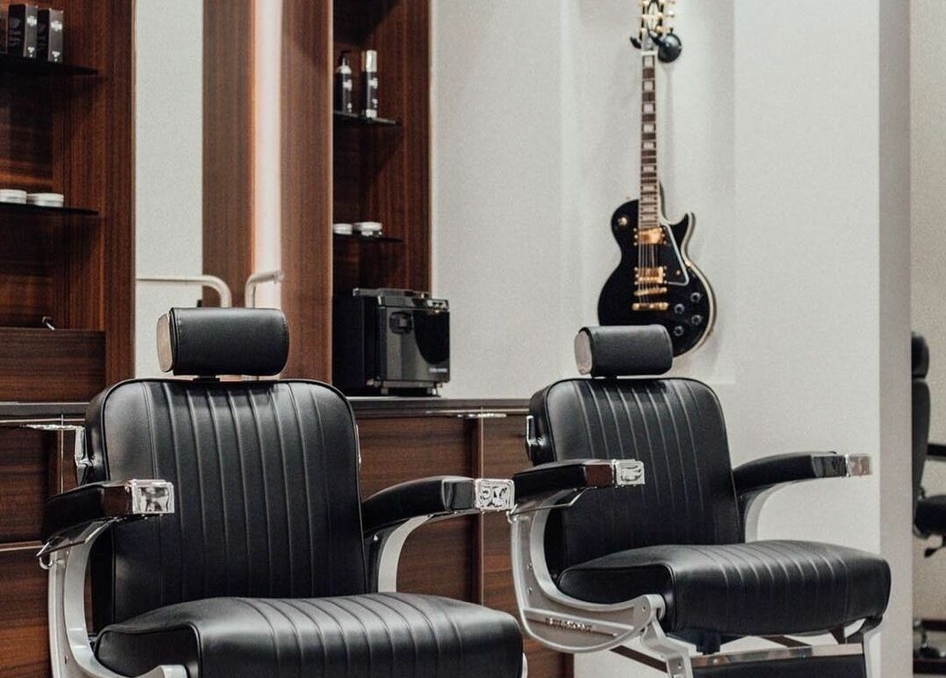 Interno moderno di The Club Barbershop - Adria, sedie di lusso e chitarra a Adria, Veneto, IT.