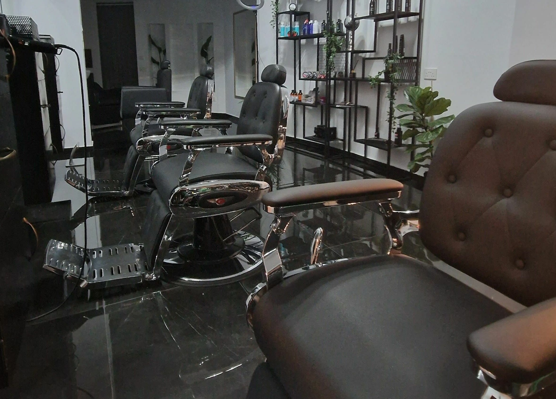 Modern barber chairs at Udomo Barber and Nail Studio, Paphos, CY, showcasing sleek black and chrome decor.