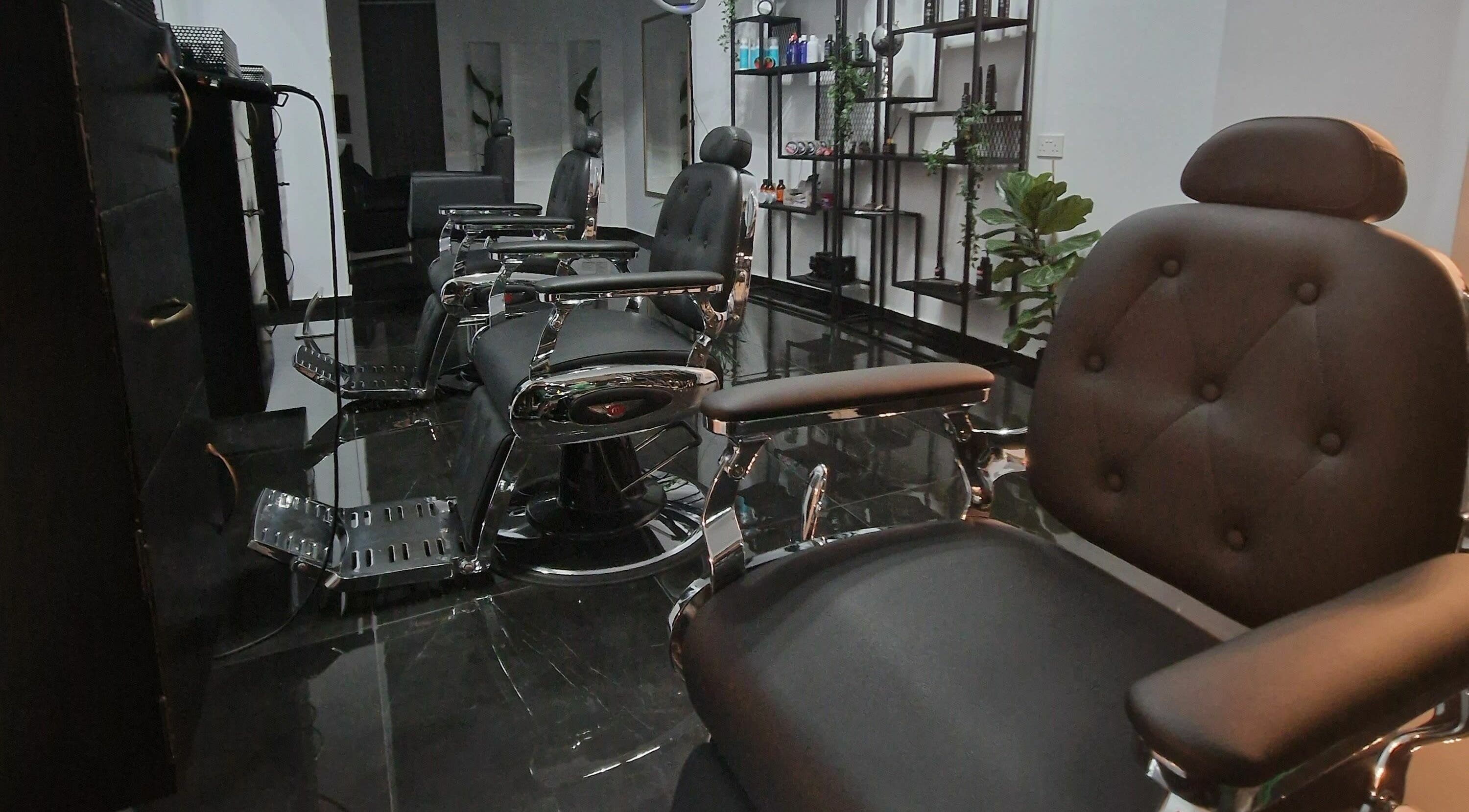 Modern barber chairs at Udomo Barber and Nail Studio, Paphos, CY, showcasing sleek black and chrome decor.