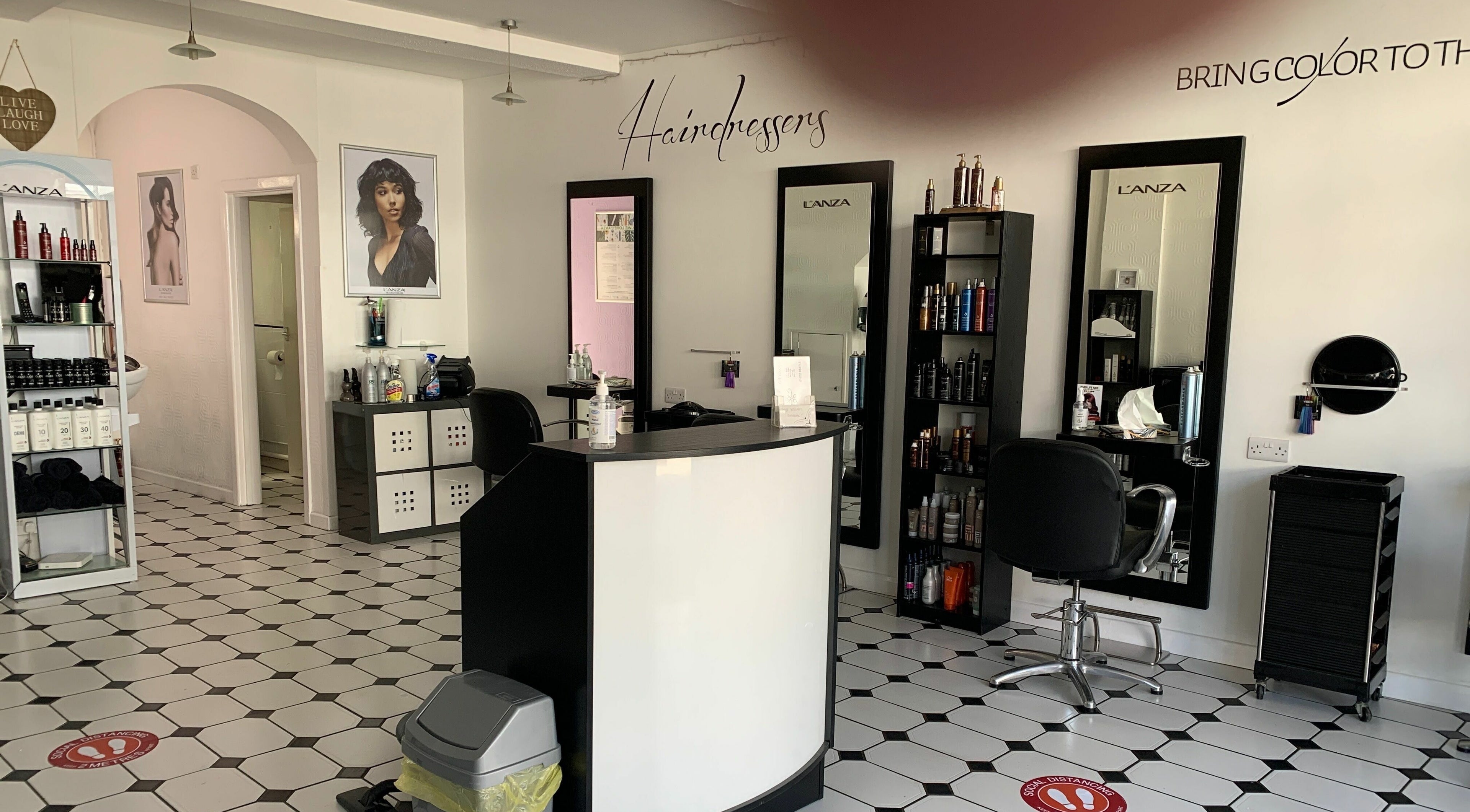 Modern salon interior of Hair Ology Wimborne in Wimborne Minster, England, showcasing stylish decor and products.