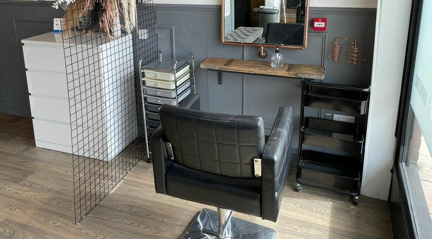 Stylish salon chair at Nelco, Holmes Chapel, England, GB. Modern decor with a mirror and storage unit.