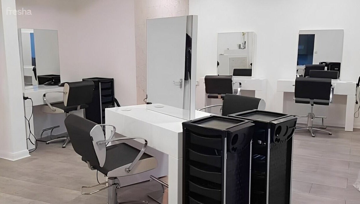 Modern salon stations at Roots in Windsor, England, GB, featuring sleek chairs and mirrors.