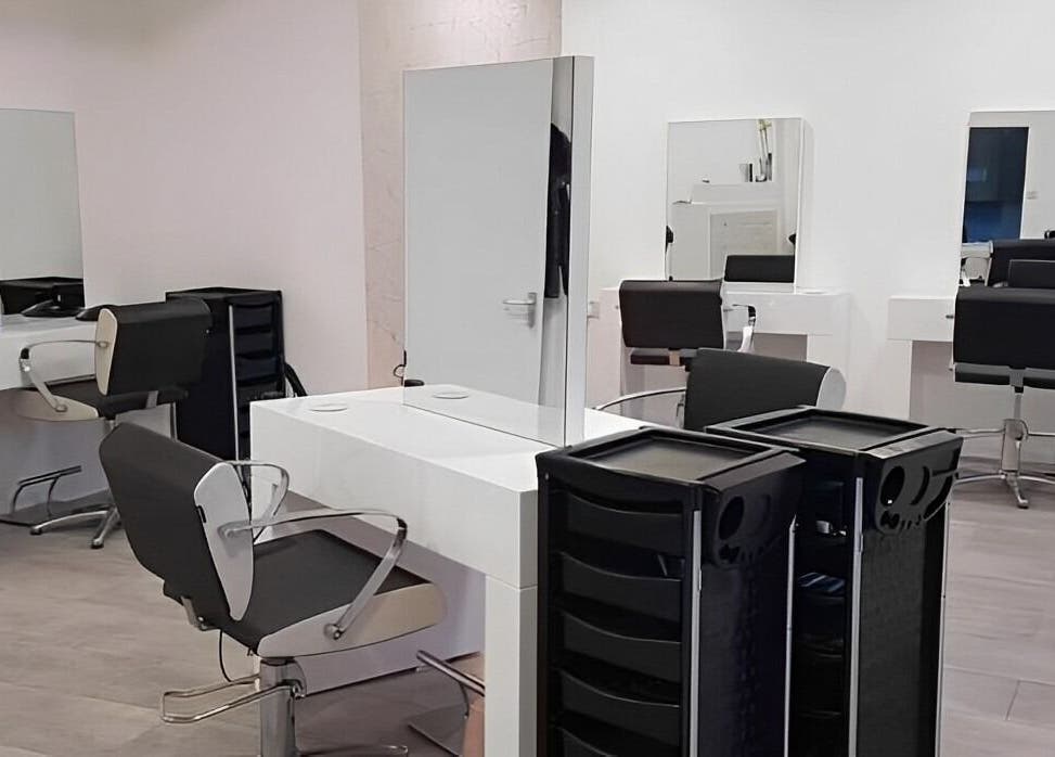 Modern salon stations at Roots in Windsor, England, GB, featuring sleek chairs and mirrors.