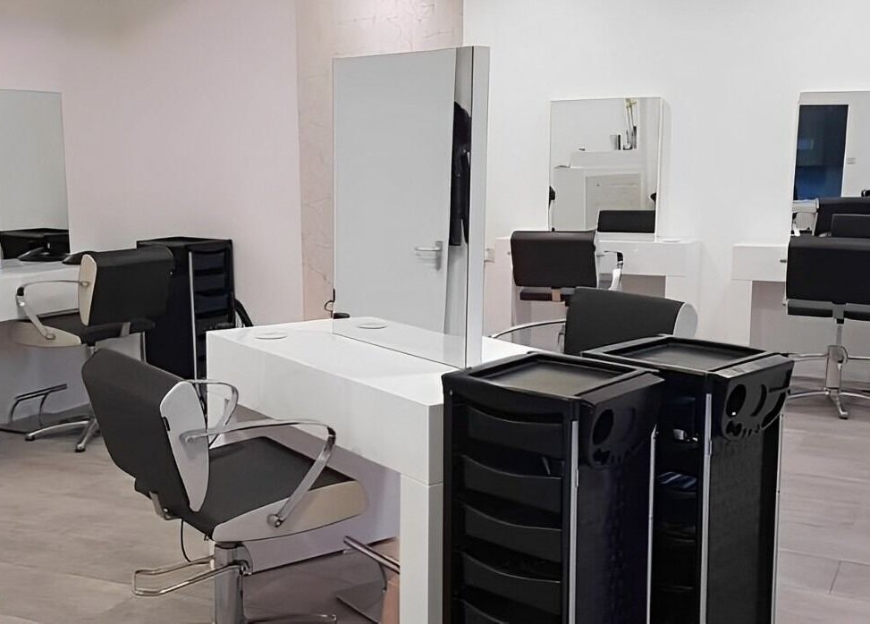 Modern salon stations at Roots in Windsor, England, GB, featuring sleek chairs and mirrors.
