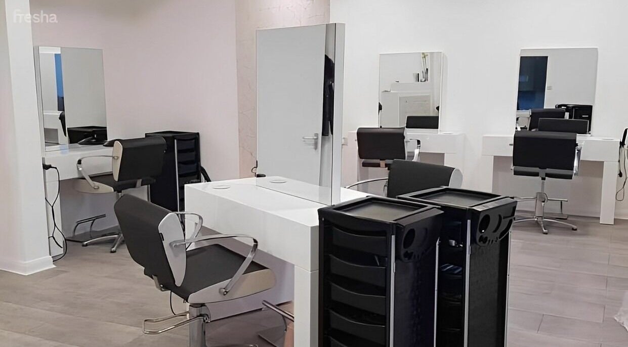 Modern salon stations at Roots in Windsor, England, GB, featuring sleek chairs and mirrors.
