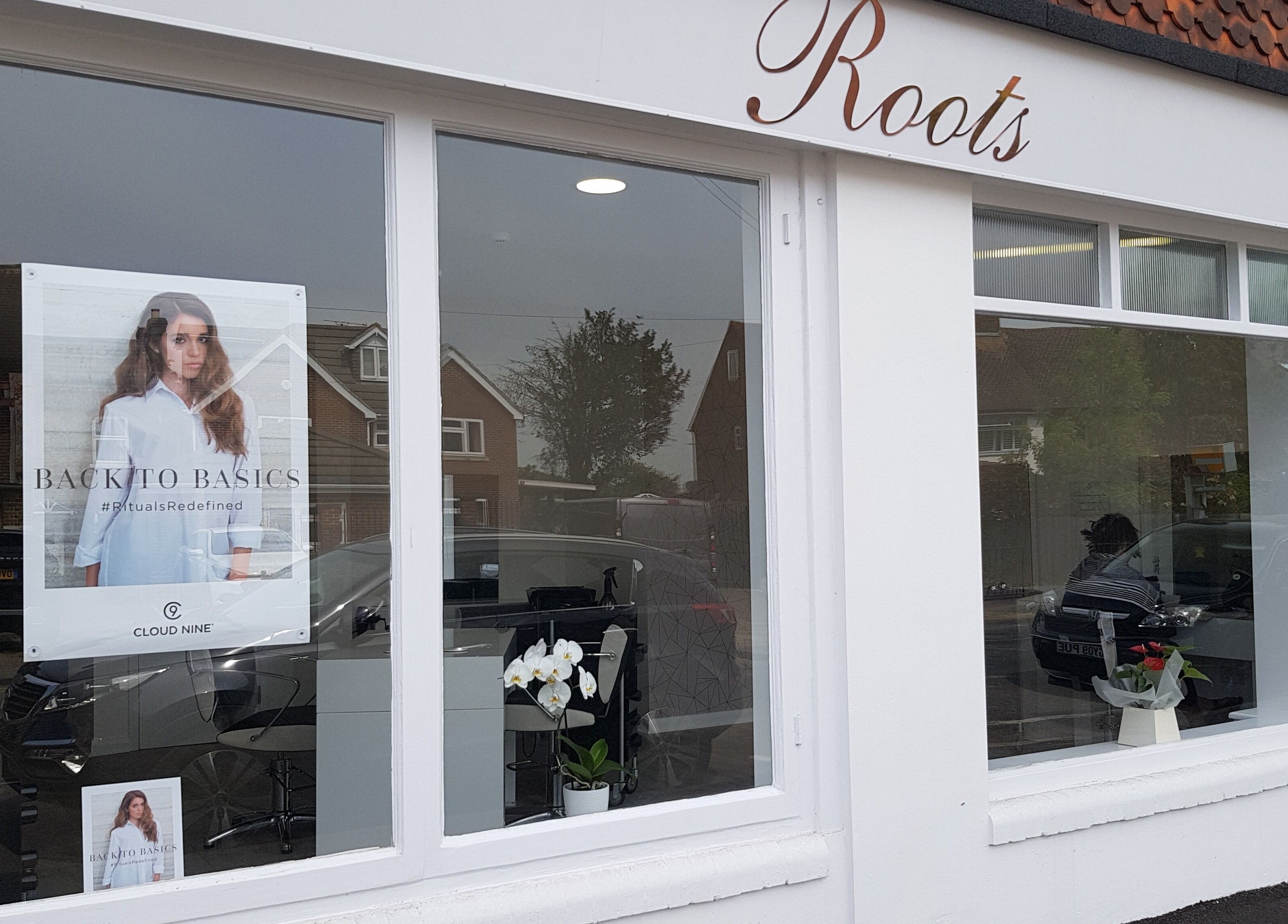 Exterior of Roots hair salon in Windsor, England, GB, showcasing stylish window display and elegant signage.