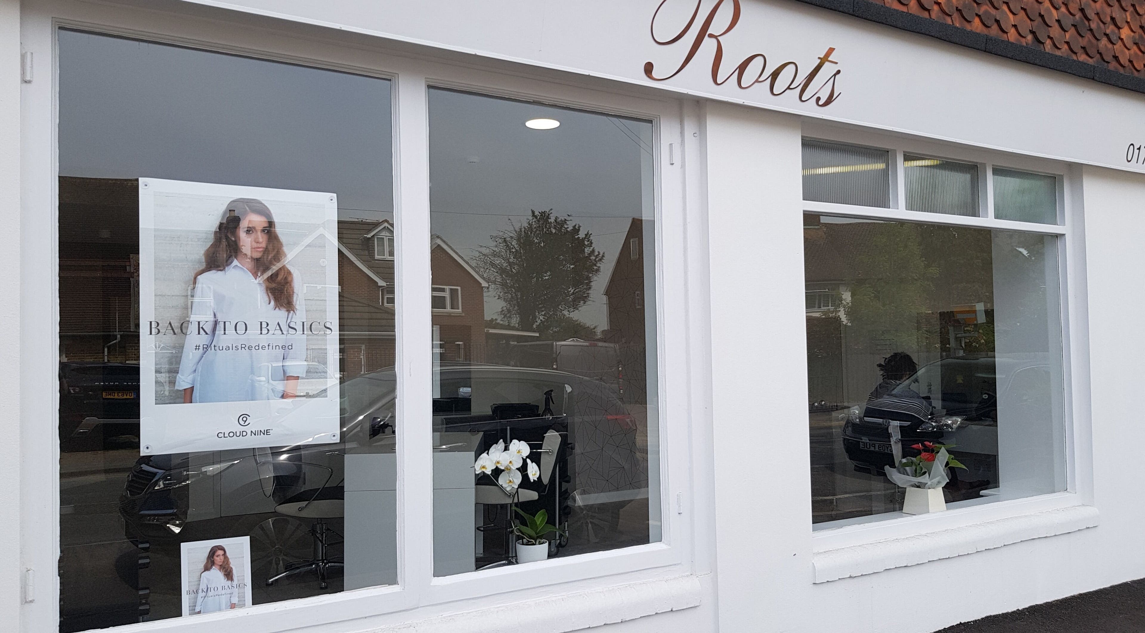 Exterior of Roots hair salon in Windsor, England, GB, showcasing stylish window display and elegant signage.