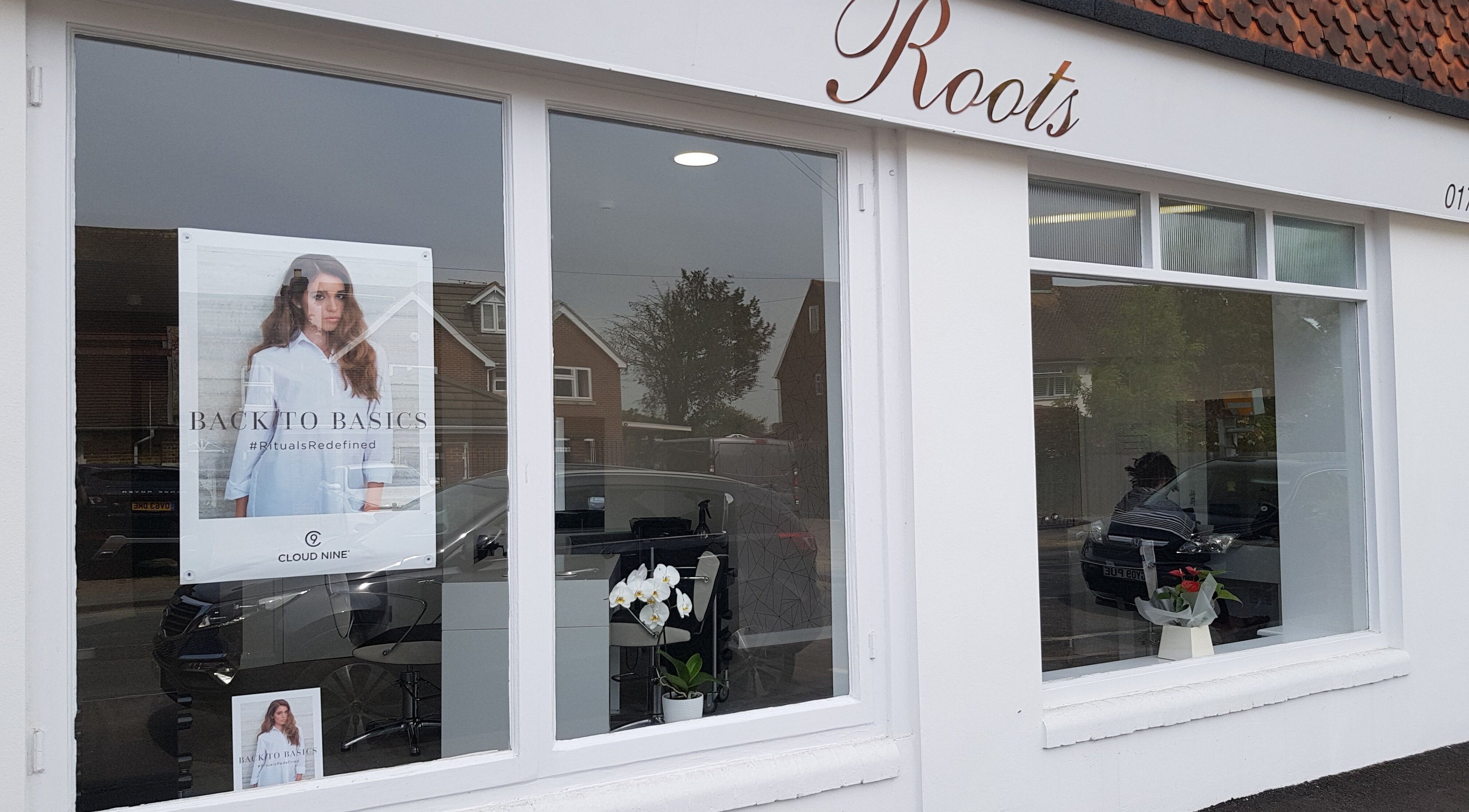 Exterior of Roots hair salon in Windsor, England, GB, showcasing stylish window display and elegant signage.