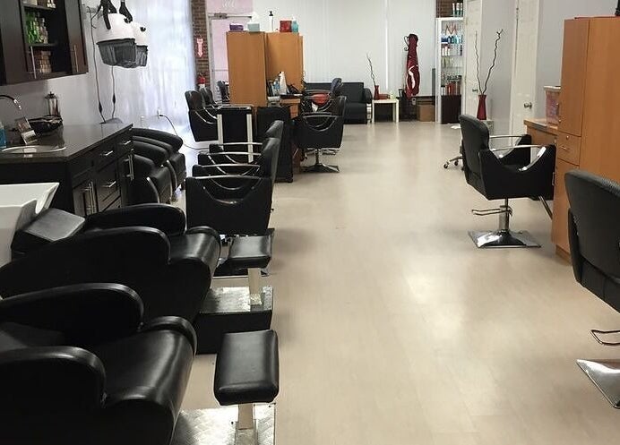 Modern interior of Xclusive Salon Suites, Clinton, Maryland, US, showcasing sleek black chairs and styling stations.