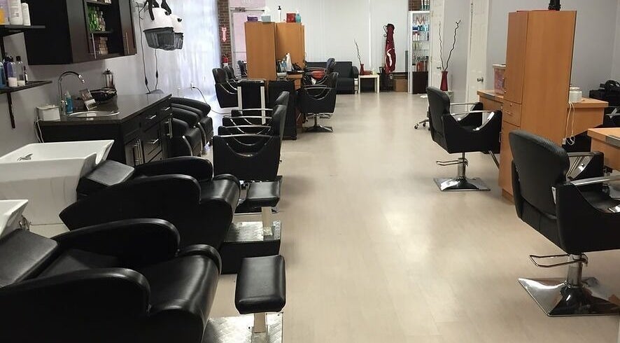 Modern interior of Xclusive Salon Suites, Clinton, Maryland, US, showcasing sleek black chairs and styling stations.