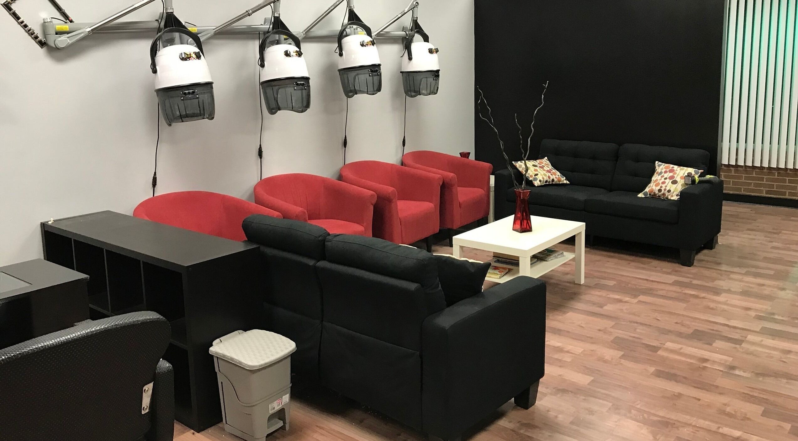 Stylish waiting area at Xclusive Salon Suites in Clinton, Maryland, US, featuring red and black seating.