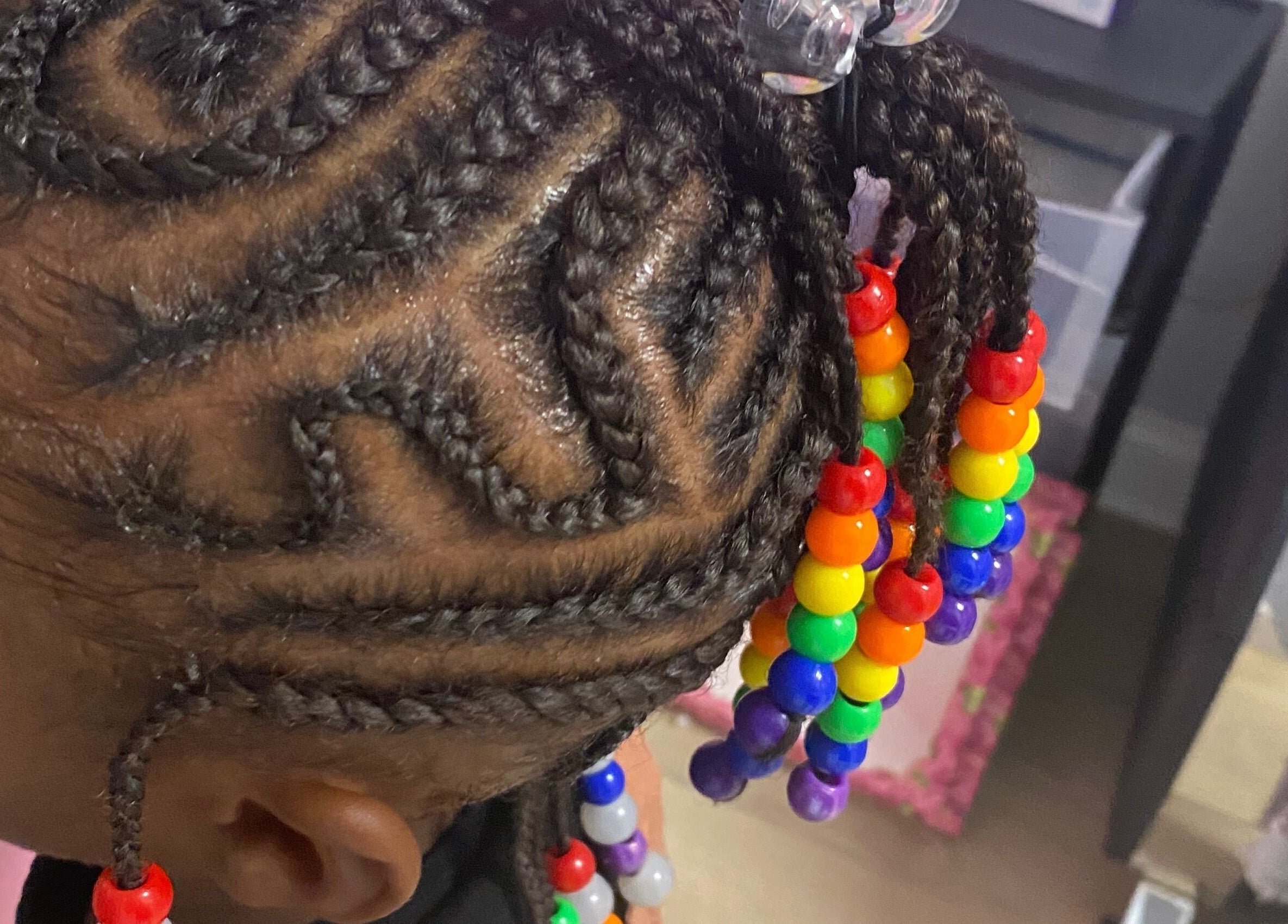 Intricate braided hairstyle adorned with colorful beads at Xclusive Salon Suites, Clinton, Maryland, US.