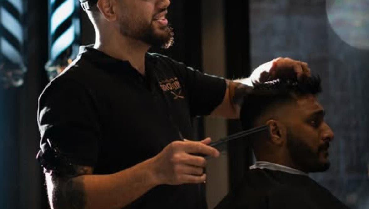 Barber at The Men's Grooming Circular Quay Gateway, Sydney, New South Wales, AU giving a stylish haircut.