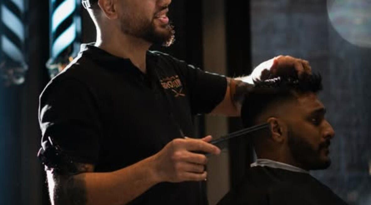 Barber at The Men's Grooming Circular Quay Gateway, Sydney, New South Wales, AU giving a stylish haircut.