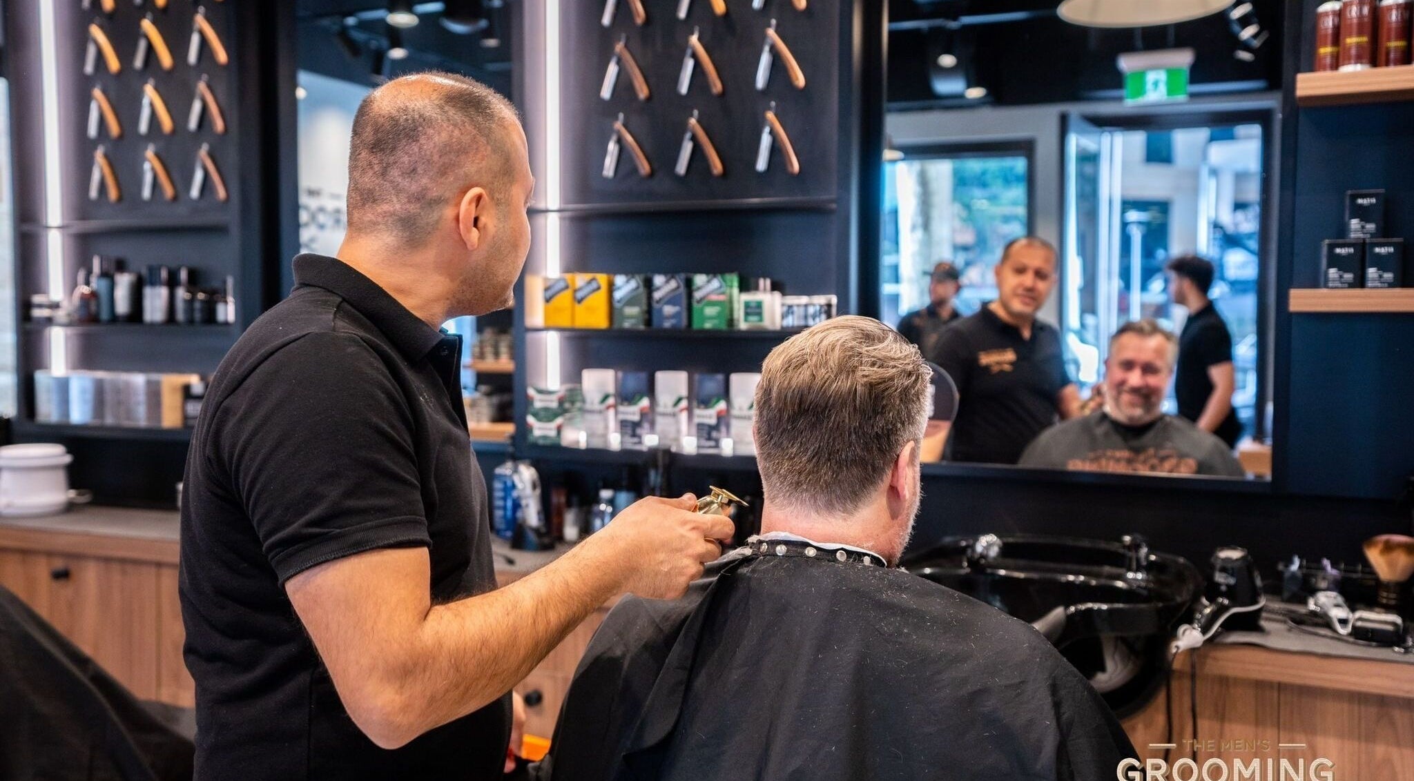 Barber styling client's hair at The Mens Grooming - Quay Quarter, Sydney, New South Wales, AU.