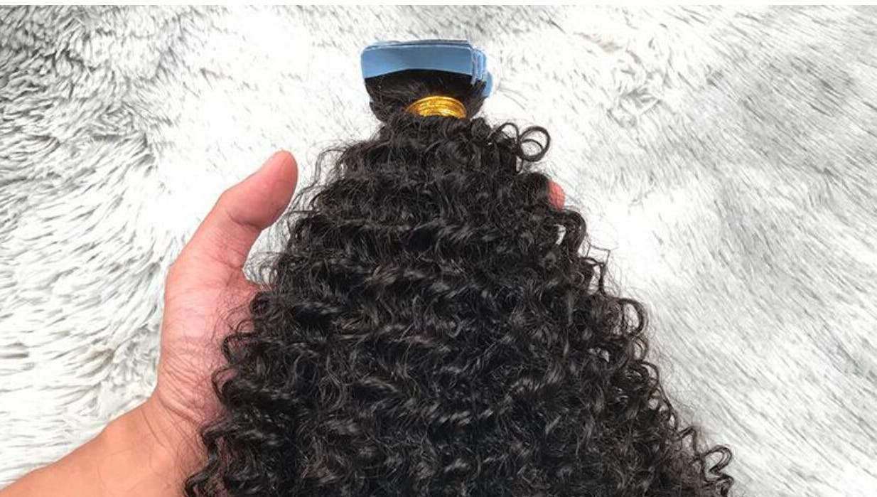 Hand holding curly hair weft at HairPlusTT, Port of Spain, Port of Spain Corporation, TT.