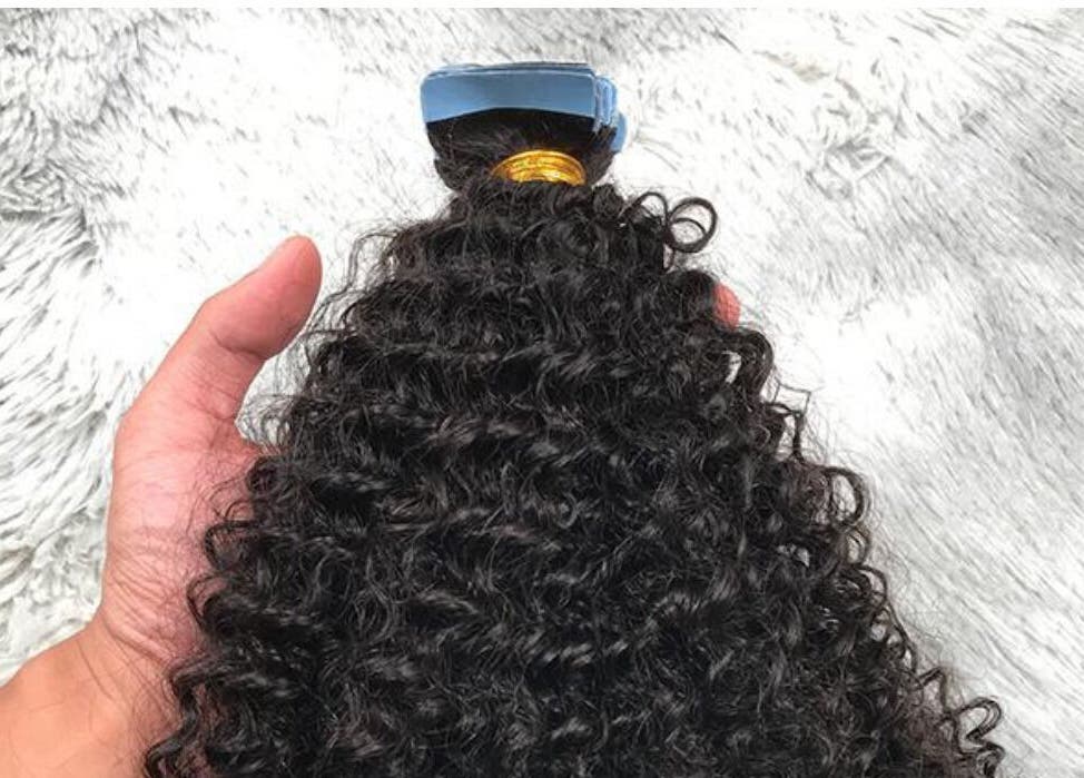 Hand holding curly hair weft at HairPlusTT, Port of Spain, Port of Spain Corporation, TT.