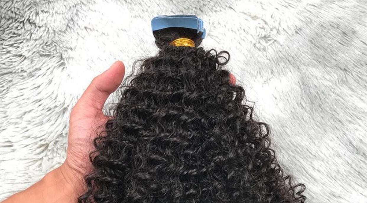 Hand holding curly hair weft at HairPlusTT, Port of Spain, Port of Spain Corporation, TT.