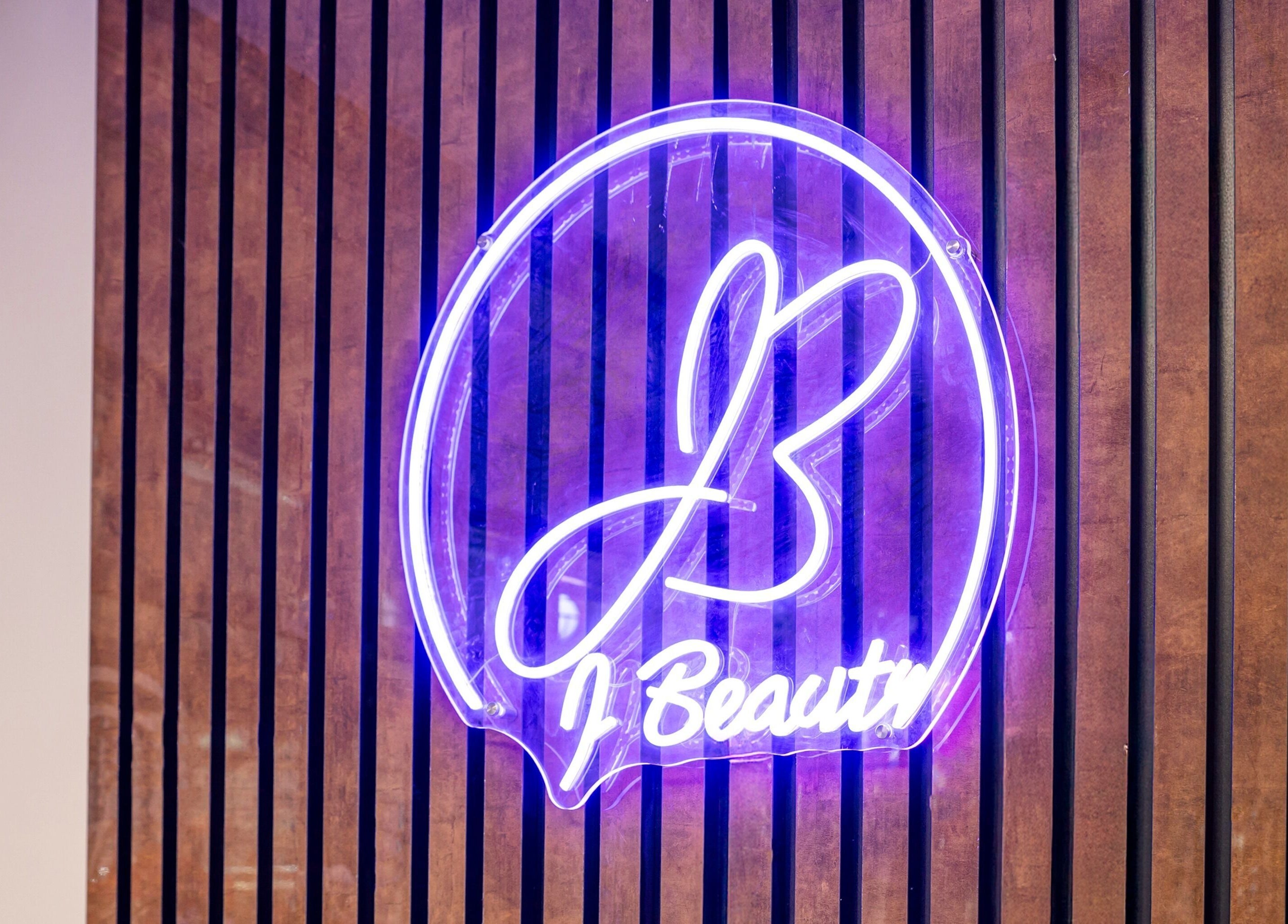 Neon sign of J Beauty by Nilima on wood panel in Birmingham, England, GB.
