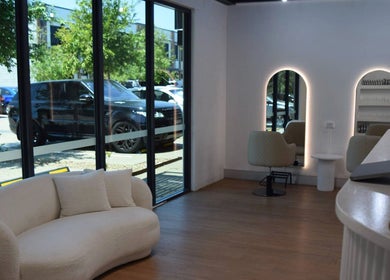 Modern interior of Hair by Jessie - Hervey Bay in Pialba, Queensland, AU with stylish seating and large windows.