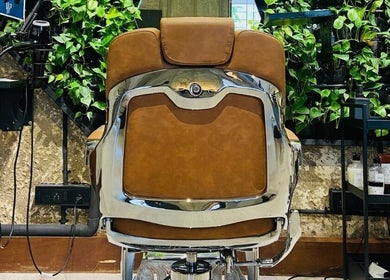 Luxurious barber chair at The Lair Man, Mumbai, Maharashtra, IN. Rustic wall and greenery enhance the serene setting.
