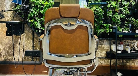 Luxurious barber chair at The Lair Man, Mumbai, Maharashtra, IN. Rustic wall and greenery enhance the serene setting.
