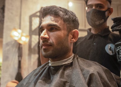 A man receives a modern haircut at The Lair Man, Mumbai, Maharashtra, IN, showcasing expert barber style.